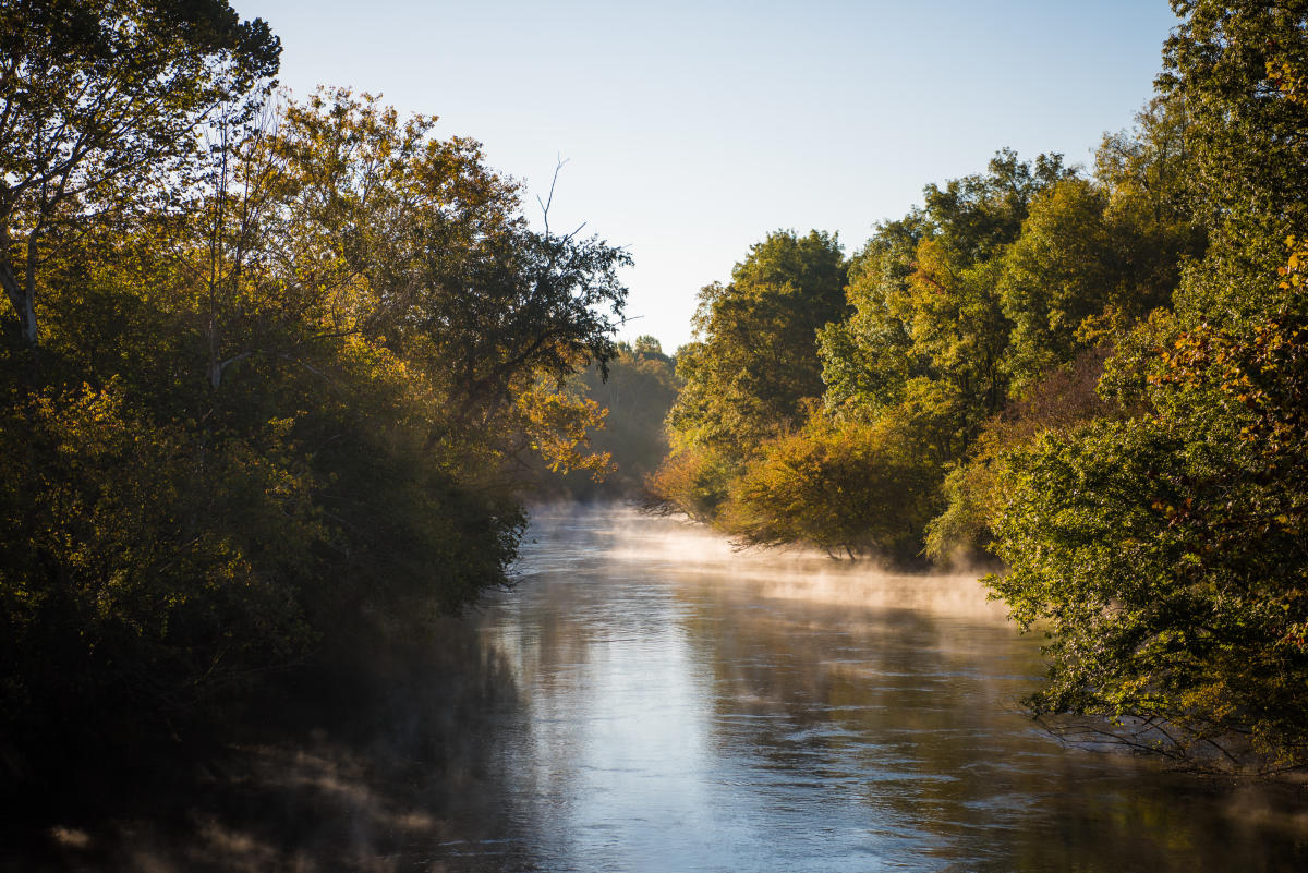 steamy river on fall morning with sunlight and colors