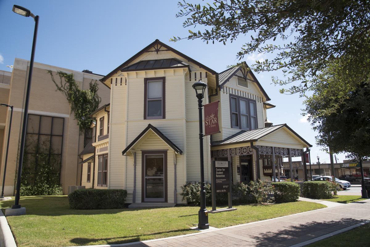 A street view photo of the Alumni House on the Texas State campus in San Marcos