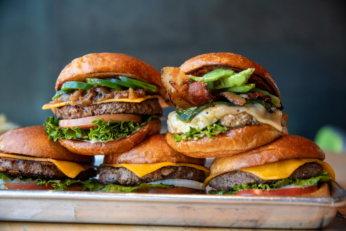 A photo of two Hopdoddy Burger Bar burgers stacked onto three