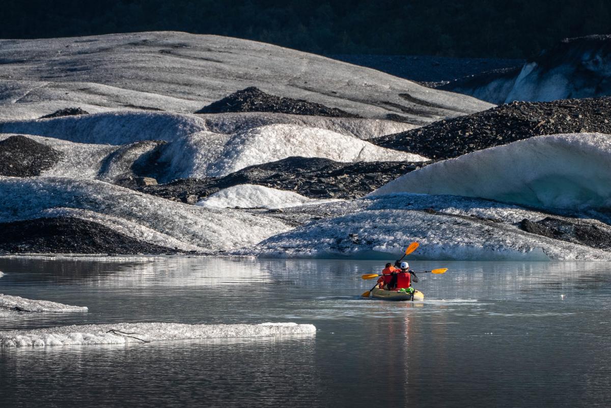 Kayakers enjoy a paddle around the ice on Valdez Glacier Lake.