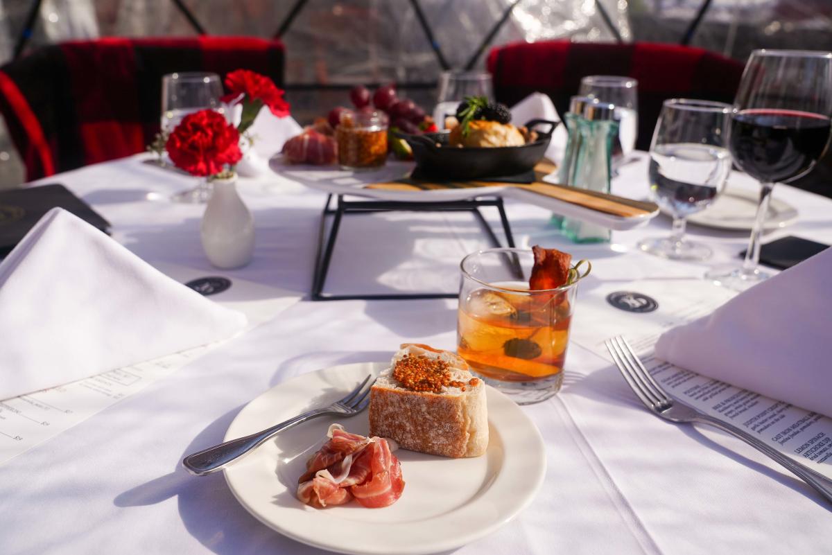 Small plate of food on a table in an igloo at The Queensbury Hotel