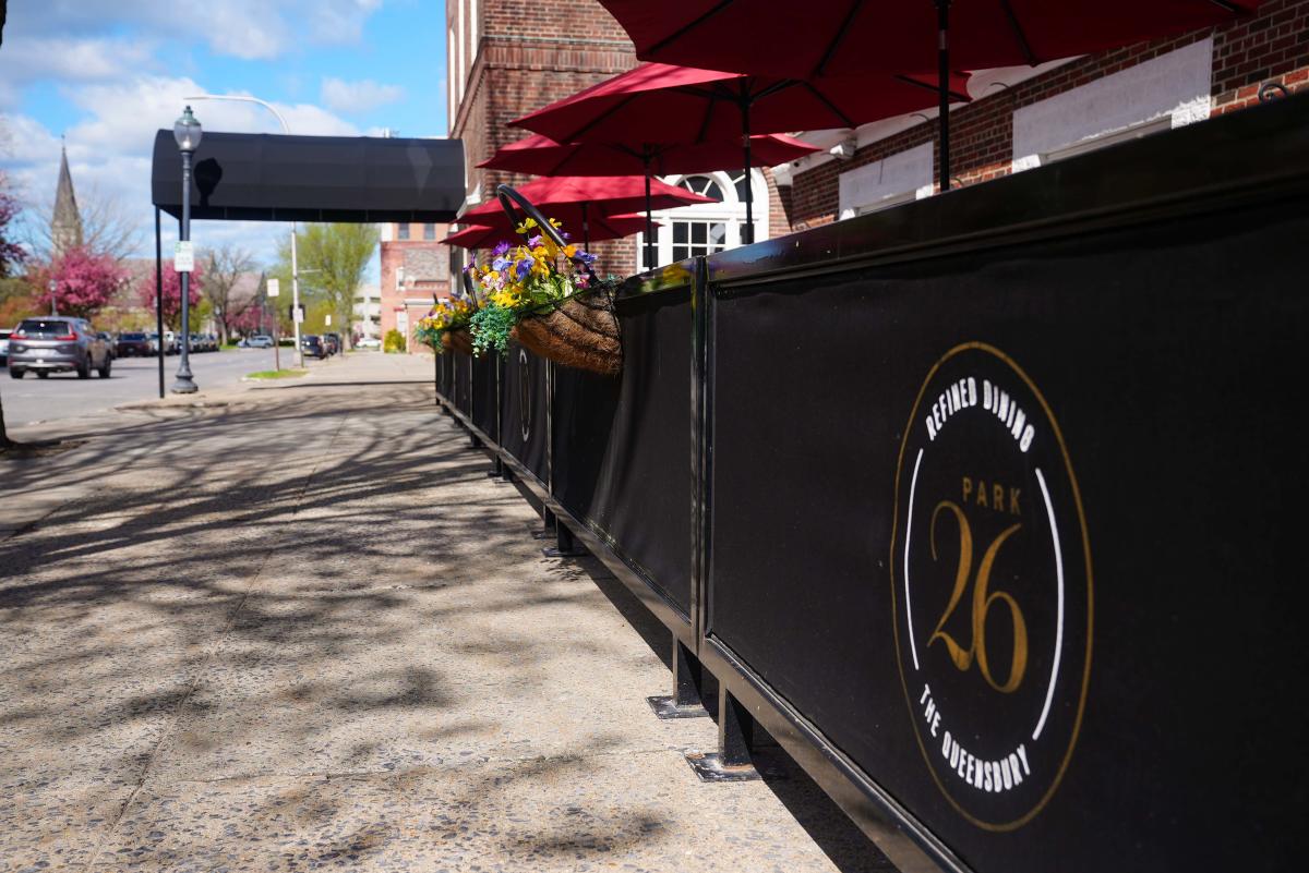Baskets of flowers hanging outside of Park 26 restaurant at The Queensbury Hotel