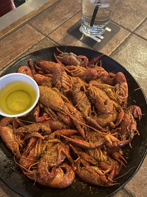 large plate of cooked crawdads with dish of butter