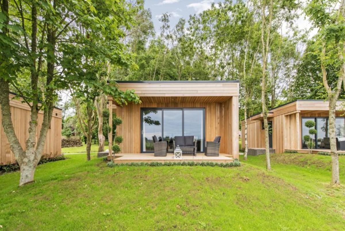 Wooden lodge with outdoor terrace set in the trees at Tinwood, Sussex
