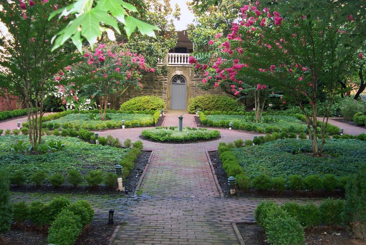 Flowering trees, garden and walkway of the Carlyle House Historic Park Garden