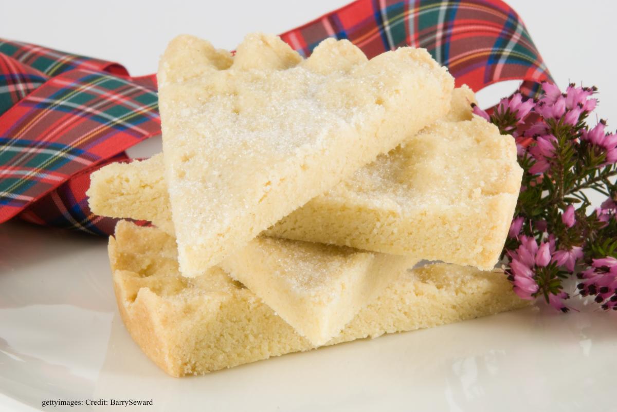 Shortbread tails on a white plate, decorated with tartan ribbon and thistle.