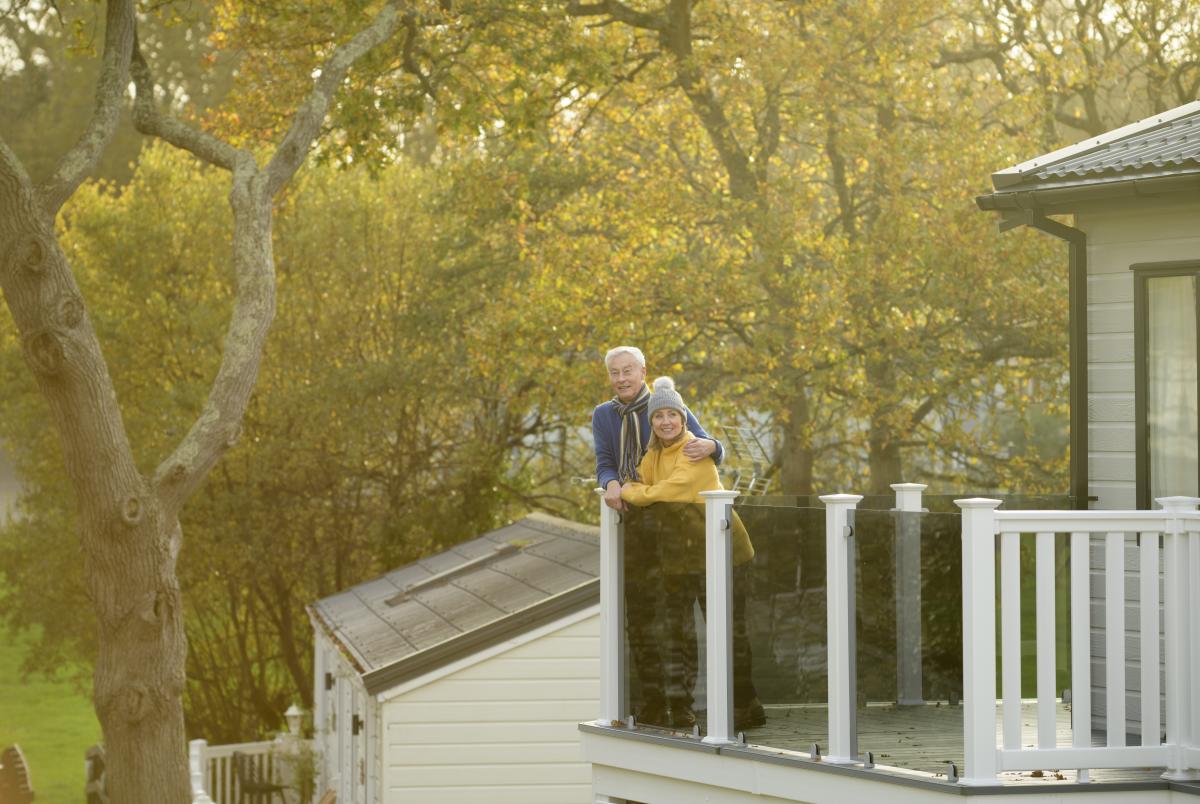 2 people standing out on balcony of holiday home at Shorefield
