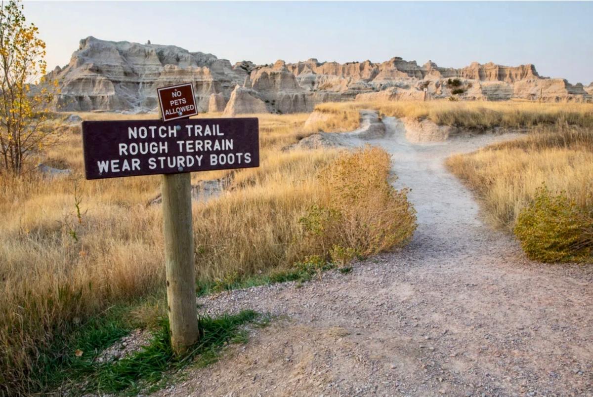 Trail sign marking Notch Trail with Badlands National Park in the background