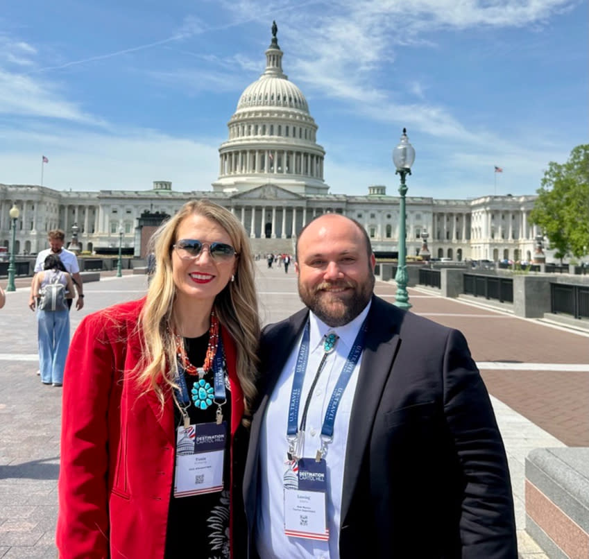 Tania Armenta and Lansing Adams stand in front of the U.S. Capitol building.
