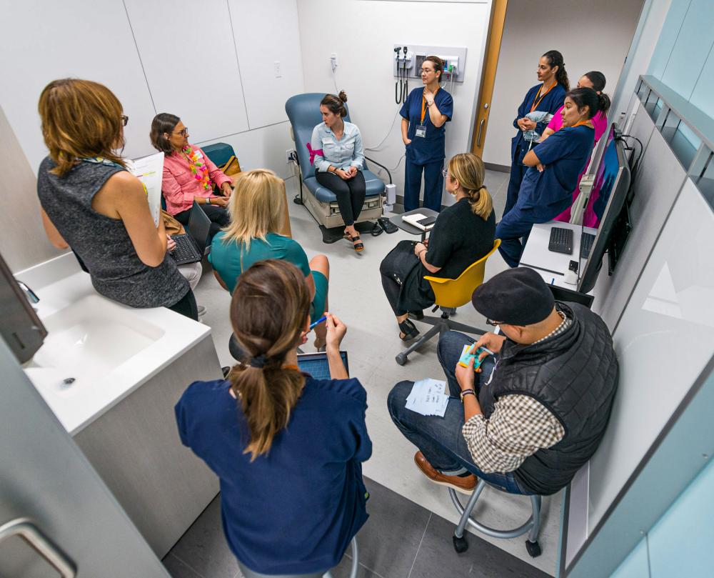 Group of med students circled together around a patient at the Dell Medical School.