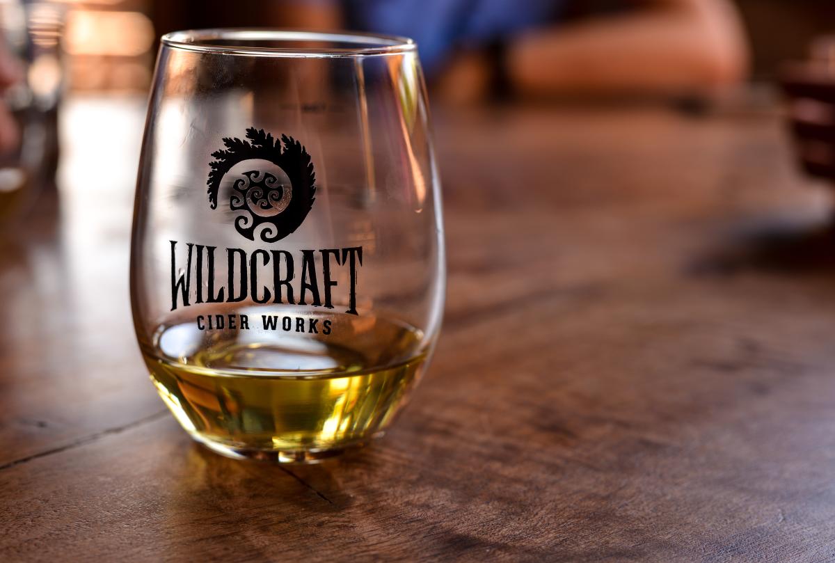 A tumbler glass is a third full of cider at Wildcraft Cider Works