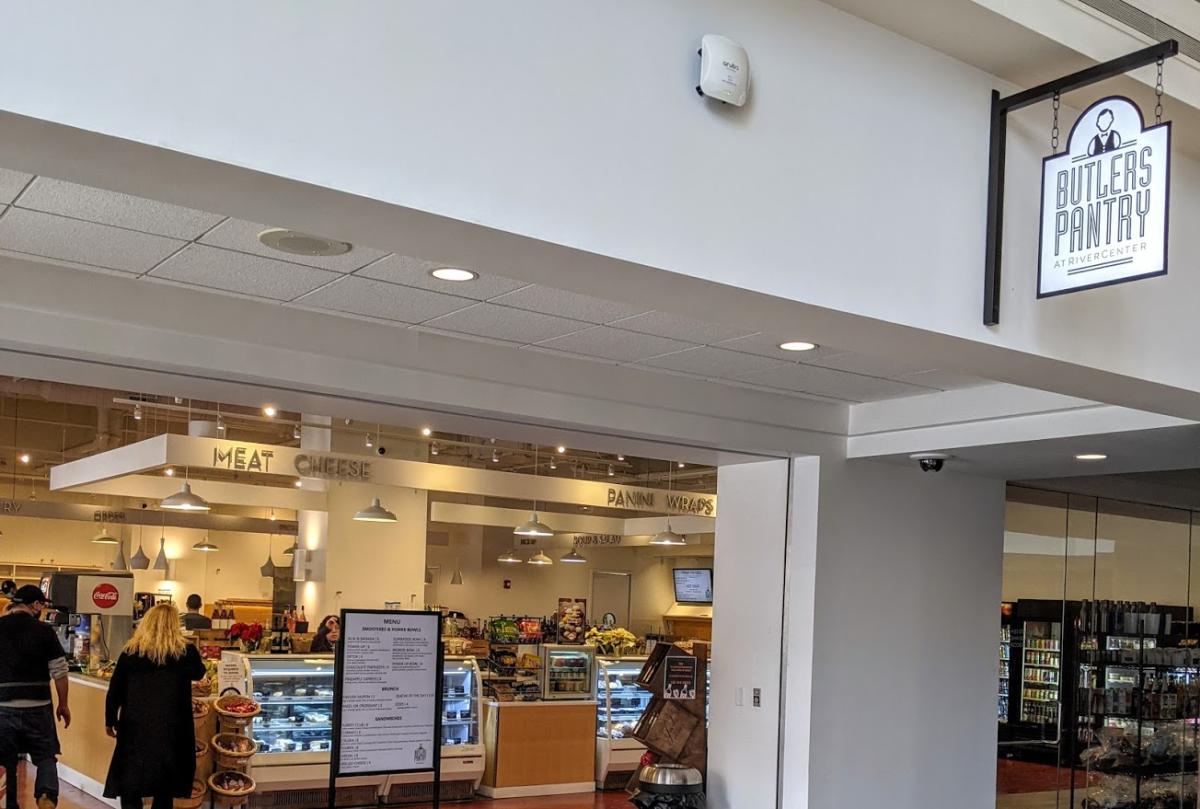 The wide opening in the wall that leads to Butler's Pantry in the Rivercenter Towers, with a case of baked goods in the background.