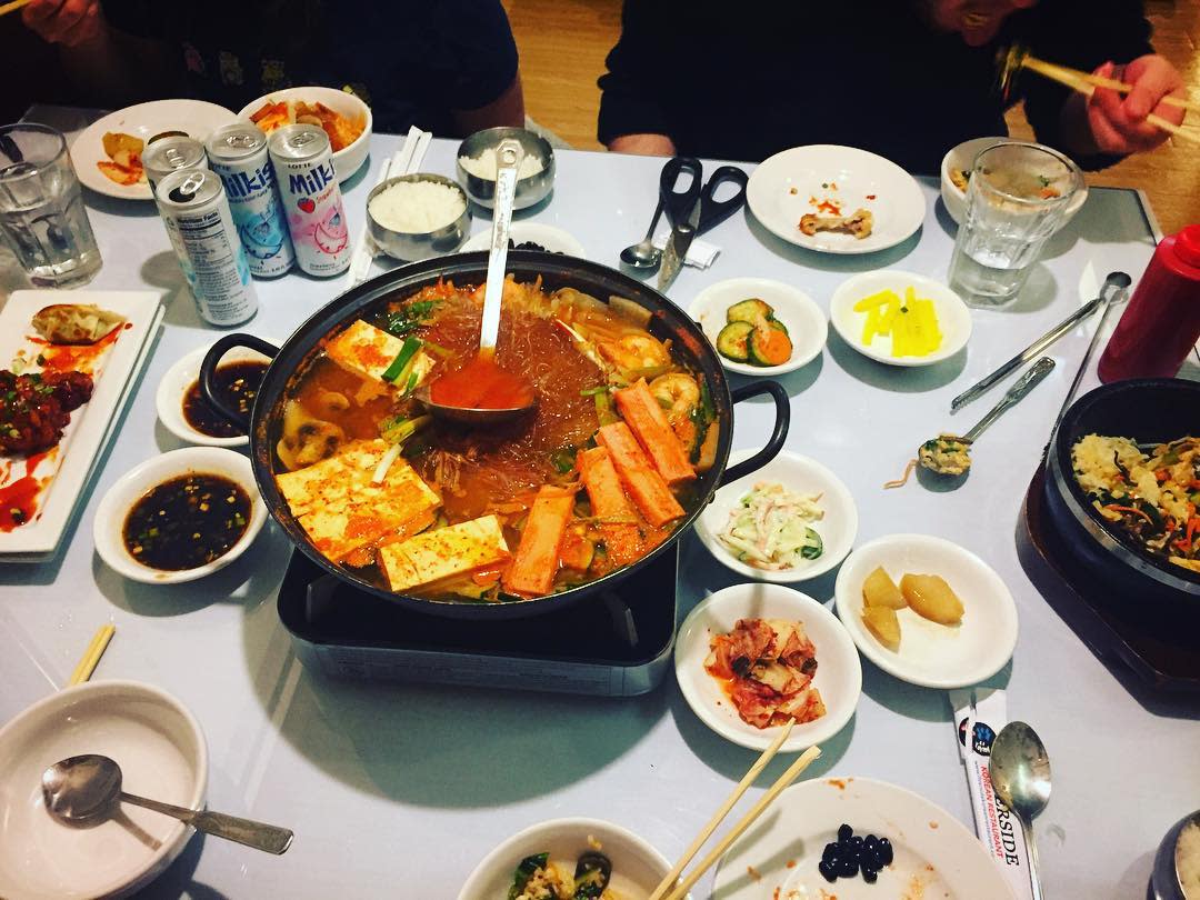 A table with white tablecloth covered in dishes from Riverside Korean in Covington, Ky.