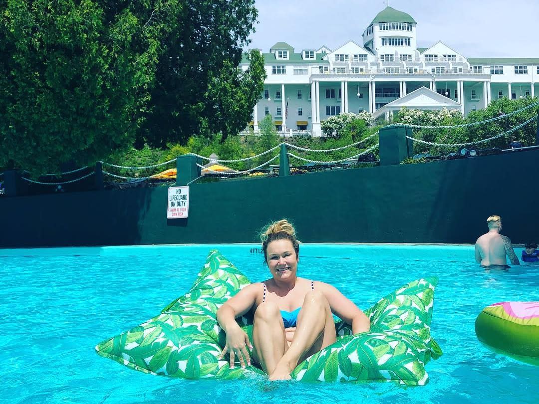 A woman sits in a swimming pool float in the water at Mackinac Island’s Grand Hotel