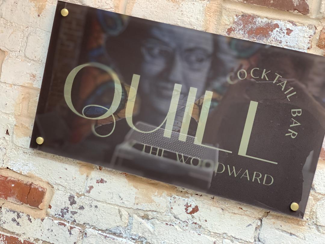 A sign for The Quill Cocktail Bar at The Woodward Hotel