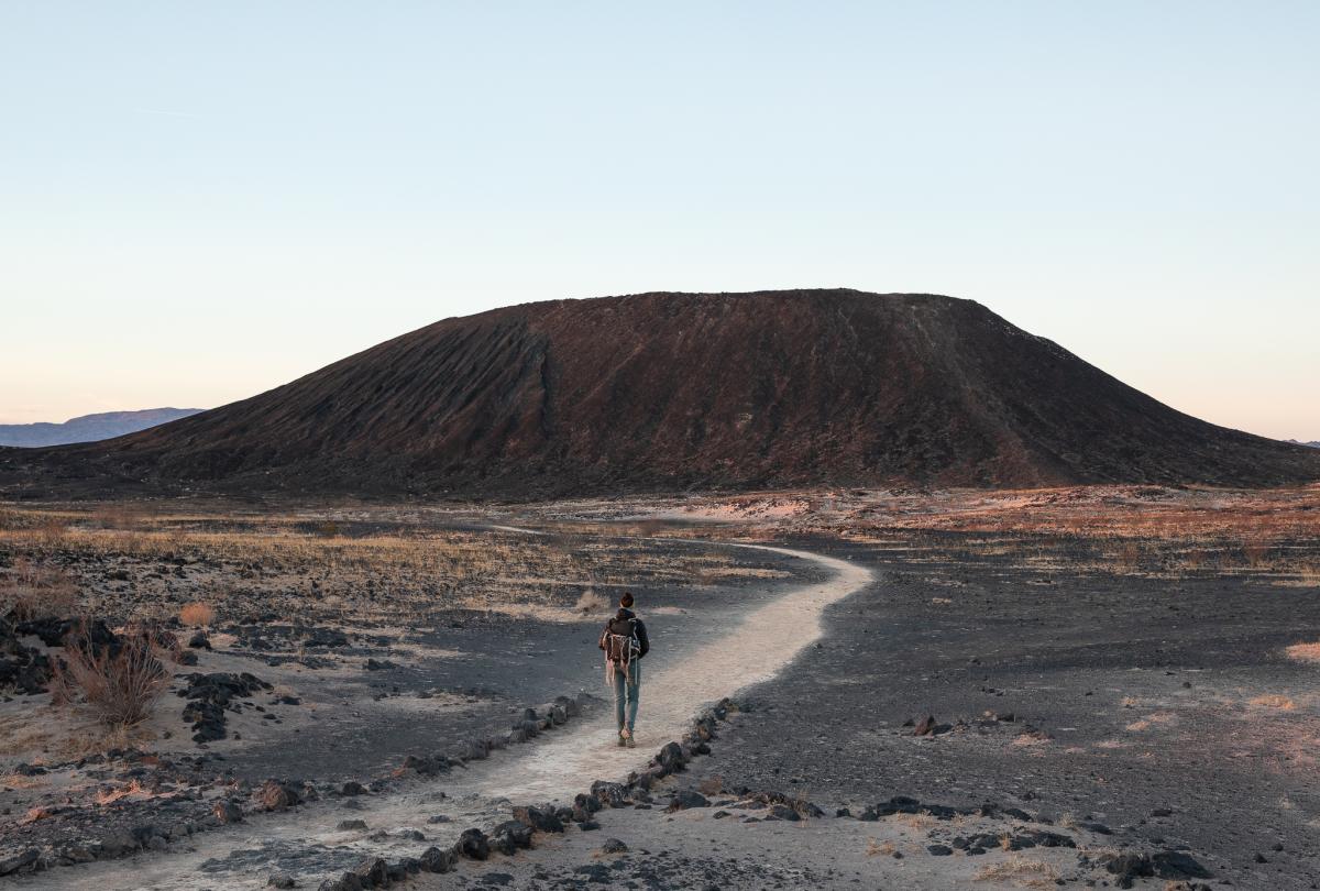 A hiker walks along the trail to Amboy Crater in Mojave Trails National Monument