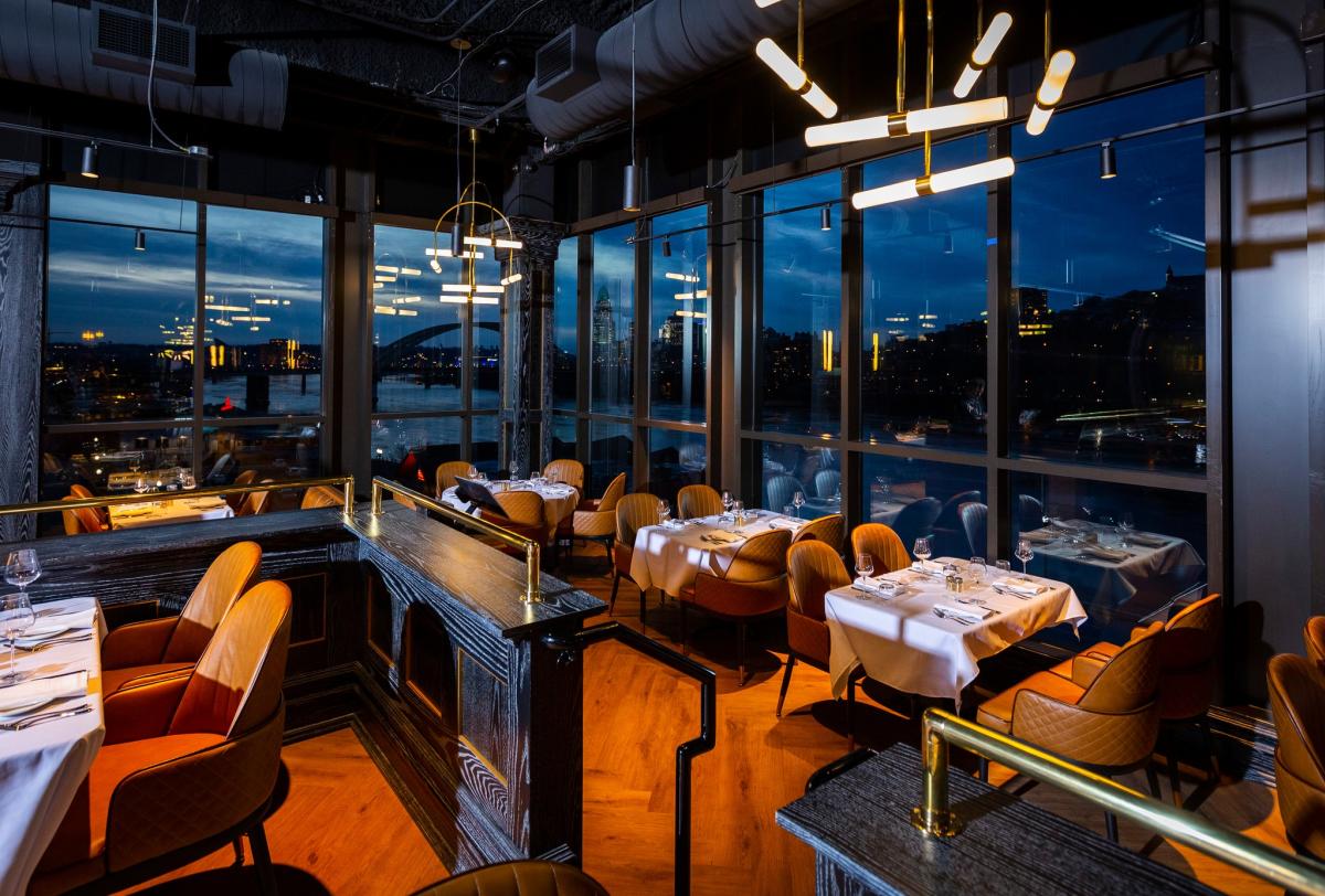 Image of the inside interior of the MRBL dining room with the City of Cincinnati in the background.