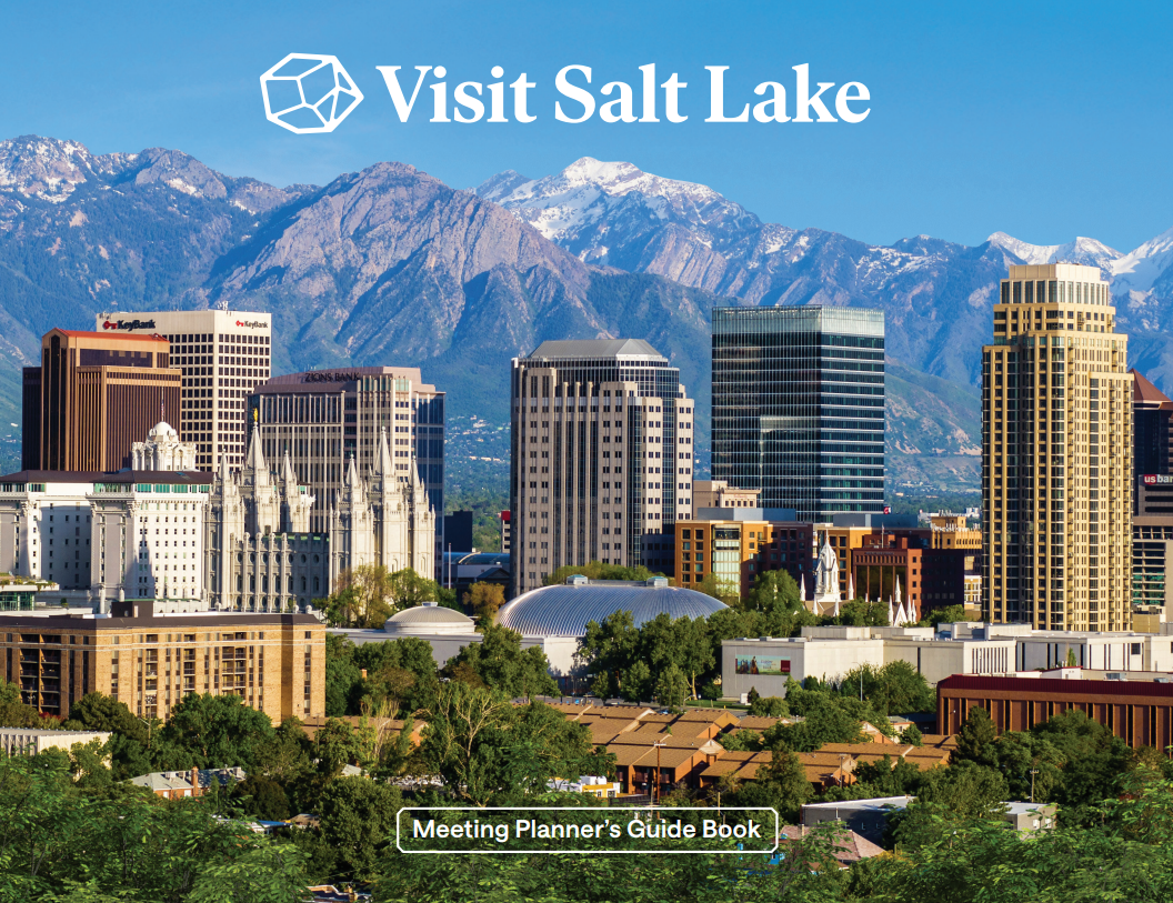 Skyline of Salt Lake with trees in the foreground, the temple and skyscrapers, then the Wasatch Mountains in the background