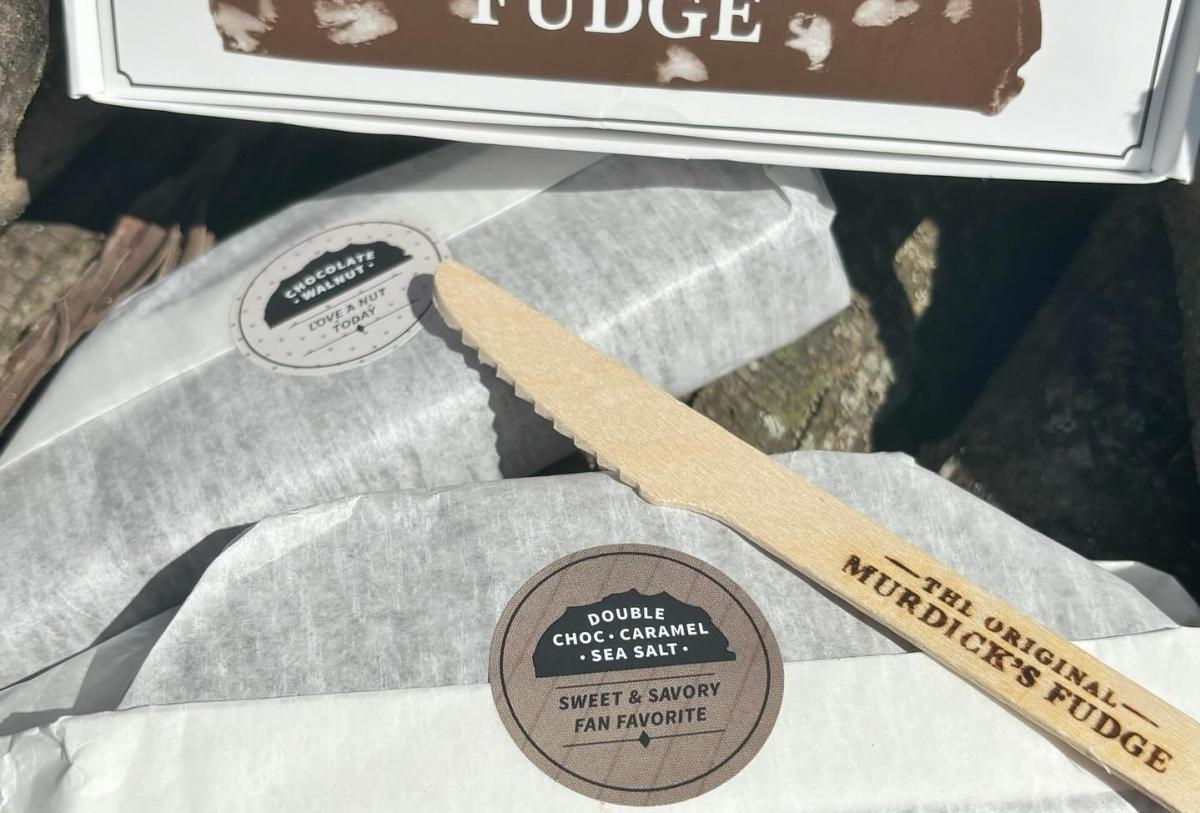 Two loaves of Mackinac Island fudge from the Original Murdick’s Fudge wrapped in white paper with a knife