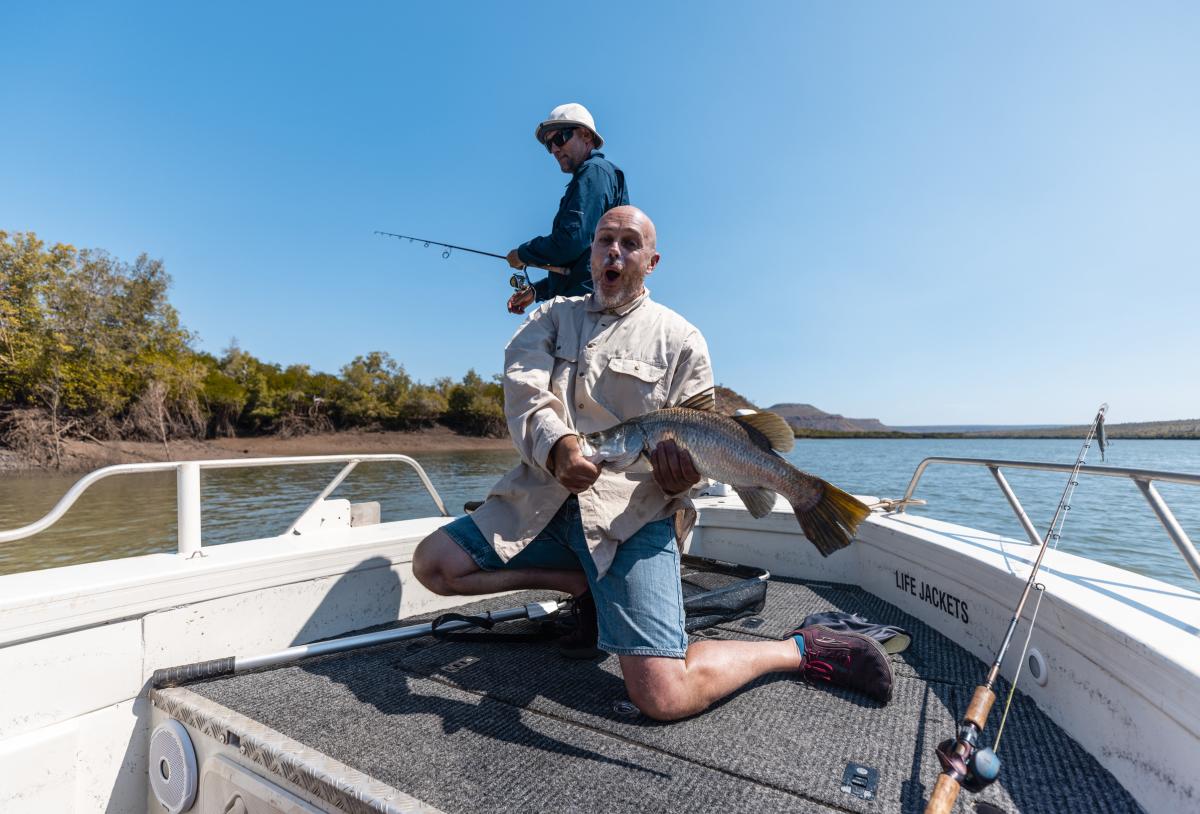 A man holding a freshly caught barramundi in the Kimberley region of Western Australia