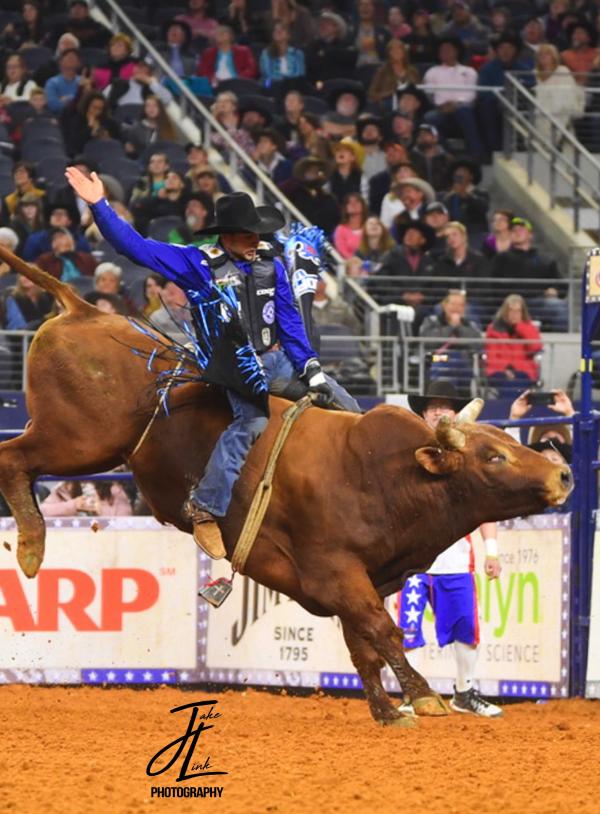 Competitor bull riding at the American Rodeo