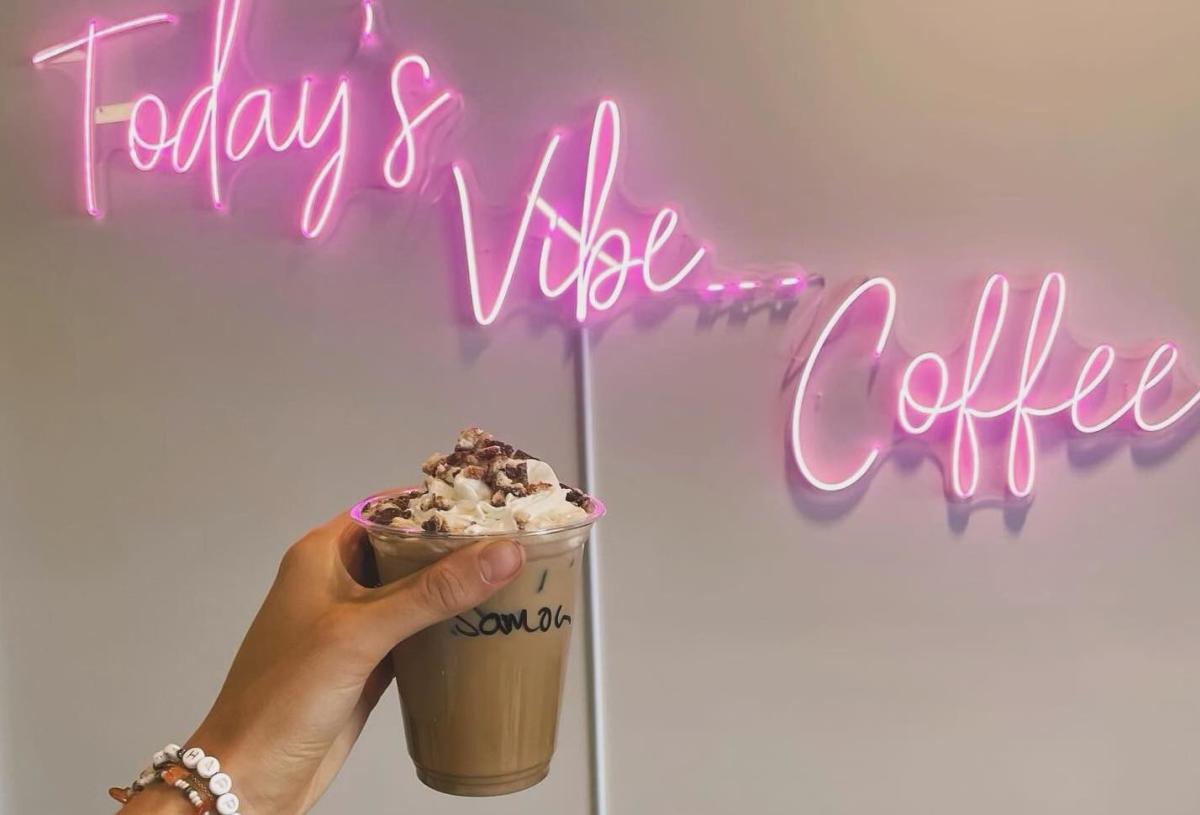 coconut summer coffee series from vibe coffee in front of a pink neon sign that reads today's vibe, coffee