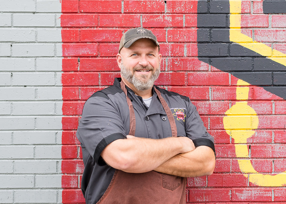 Owner Jerry Stephenson stands in front of the Redneck BBQ Lab restaurant logo in Johnston County, NC.