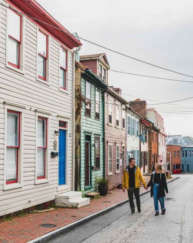 Couple holding hands, walking down historic streets of Annapolis