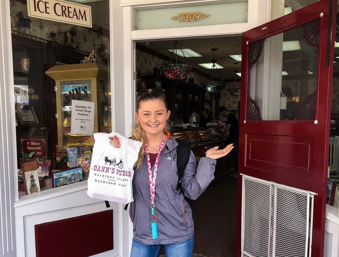 A young woman holds a bag of Joann’s Fudge outside the shop on Mackinac Island