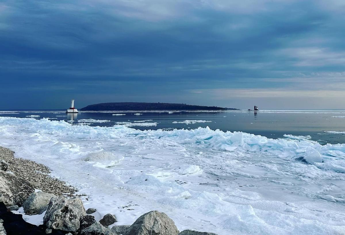 Ice forms off the shore of Mackinac Island with Bois Blanc Island, Round Island Lighthouse and Round Island Passage Light in the background