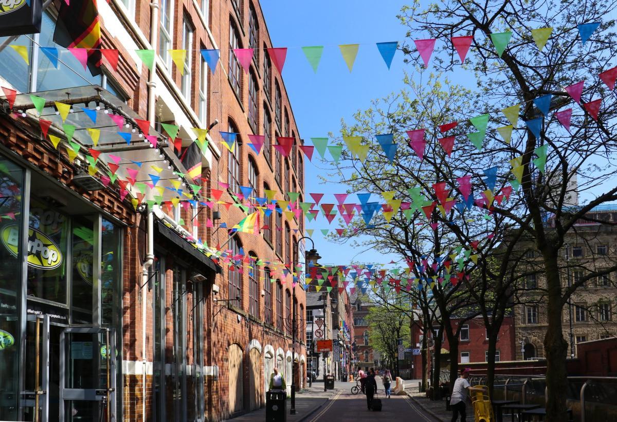 Canal Street in Manchester with coloured bunting on a sunny day