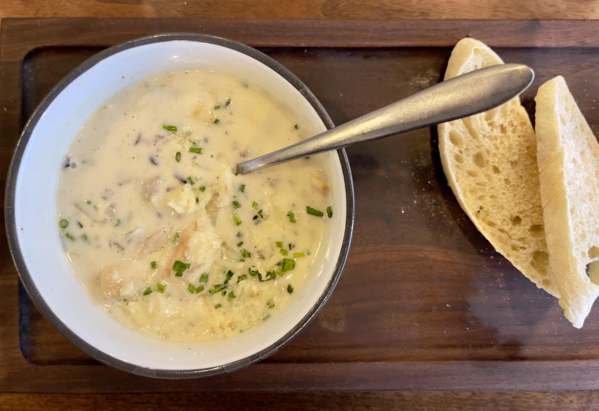 Creamy soup is served along with bread on a bread board at 1400 by Elderslie