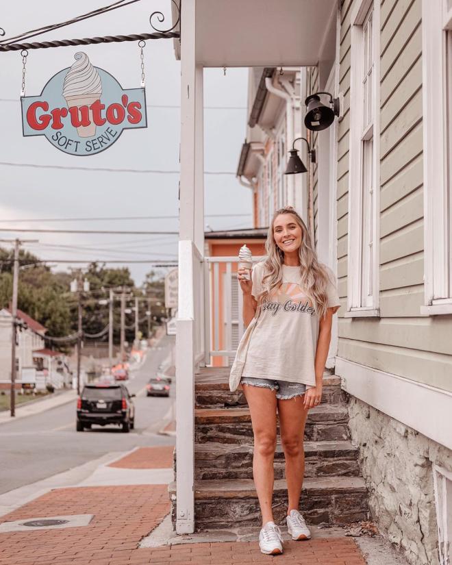 Woman holding a soft serve cone on the steps outside Gruto's Soft Serve, a local small business in Loudoun County