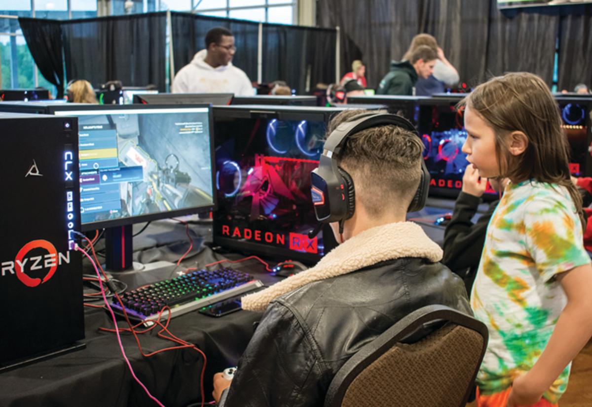 girl watches man play video game on computer