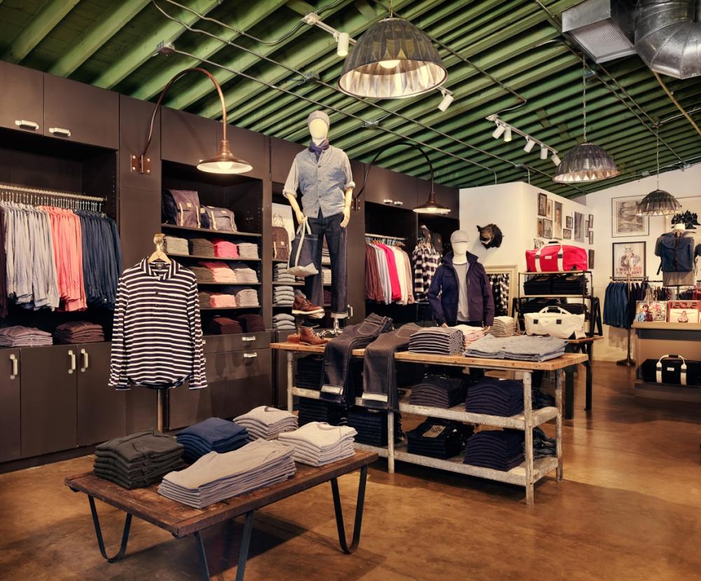 Men's clothing store with tables of folded clothing.