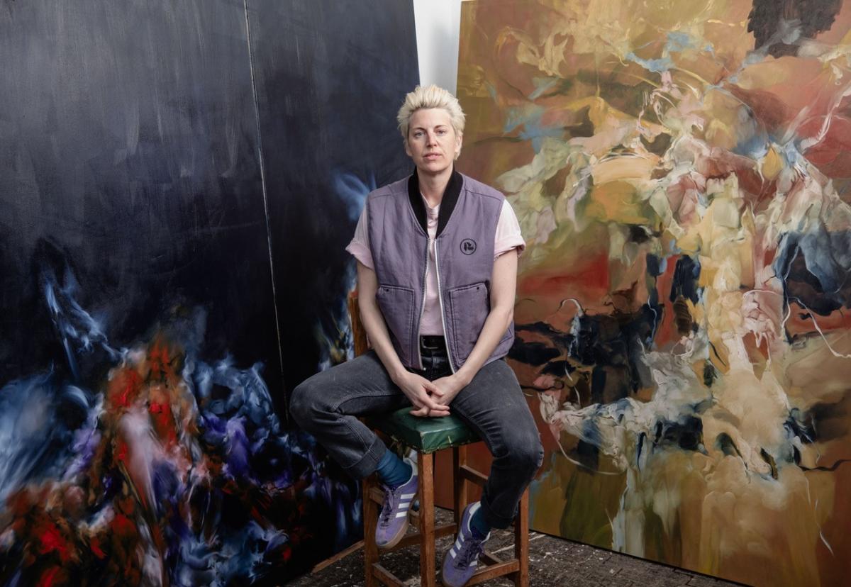 Southampton City Art Gallery: Artist Emma Richardson sat on green stool in front of large oil painting of works