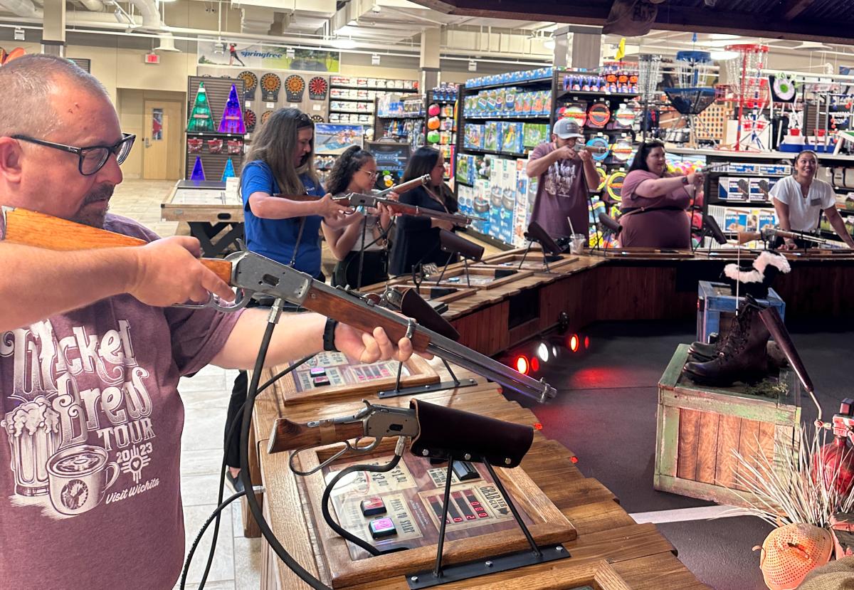 People participate in a shooting game at SCHEELS