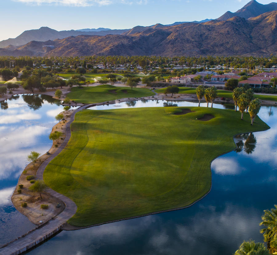 Aerial view of Tahquitz Creek Golf Resort showcasing lush fairways, reflective lakes, and desert mountain scenery in Palm Springs.