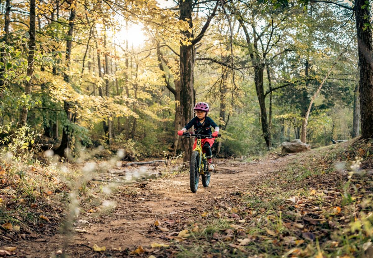 girl riding bike on wooded nature trail