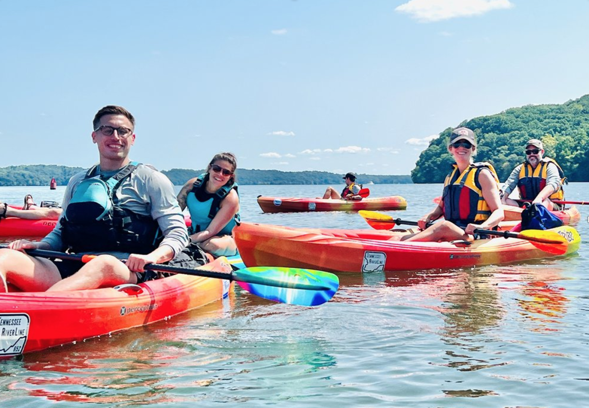 people smiling in kayaks on the tennessee river line