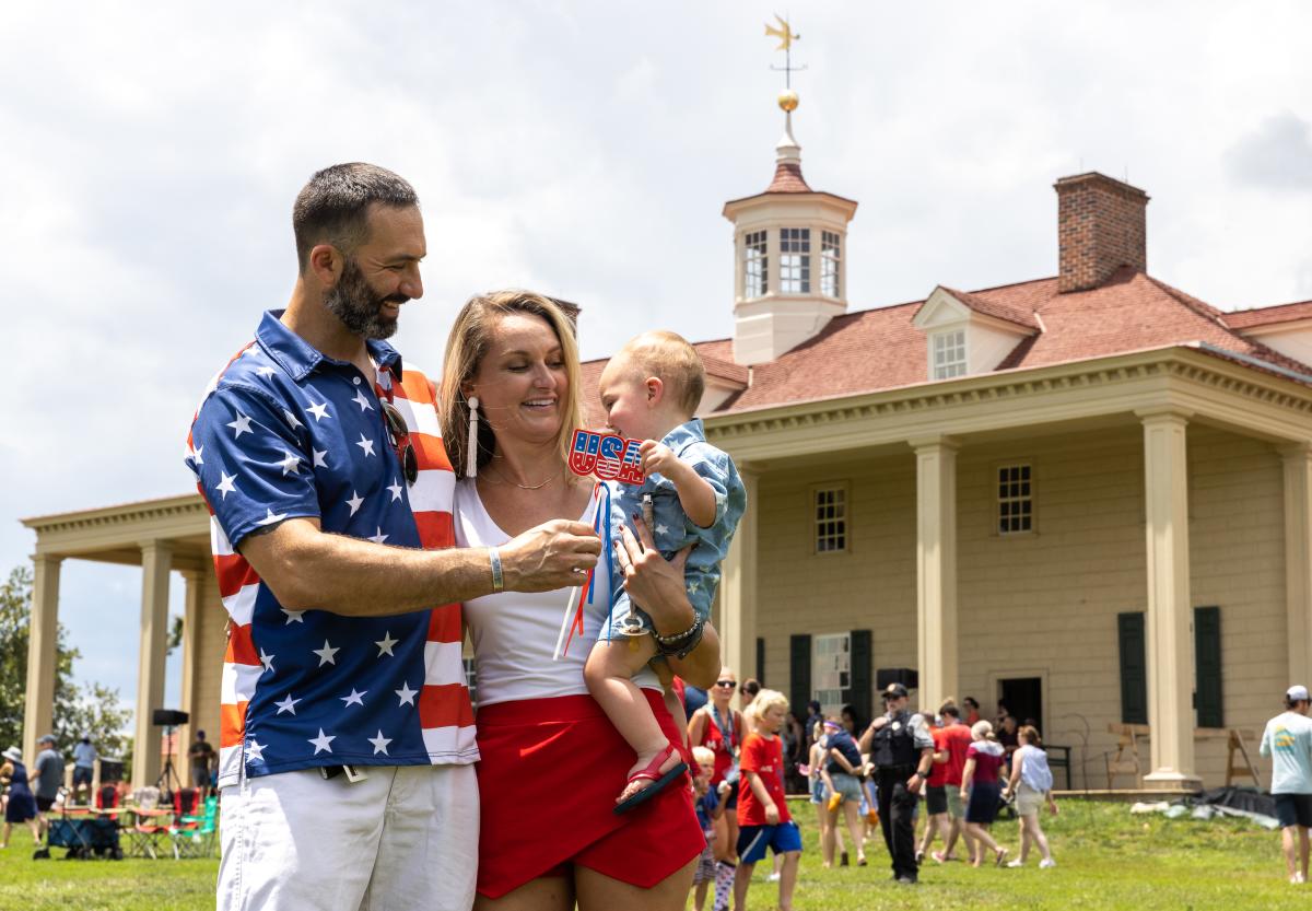 Standing Family Smiling at Camera in 4th of July Themed Clothing at George Washington's Mount Vernon.