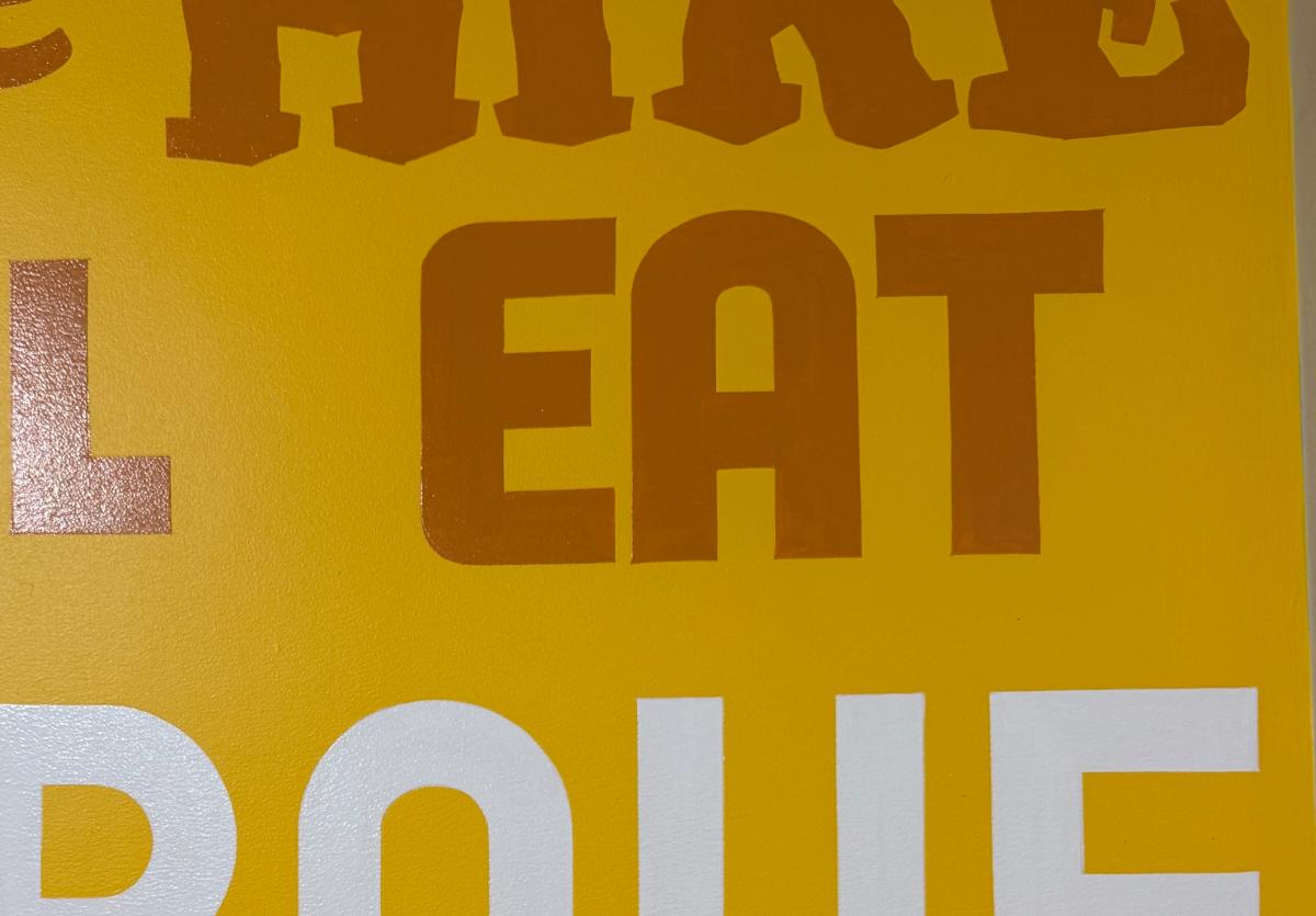 A close-up of the painted word "eat" by Chad Lindsay at the Route 66 Information Station.