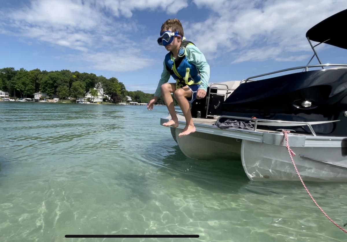 kid on the end of a boat about to jump into the water