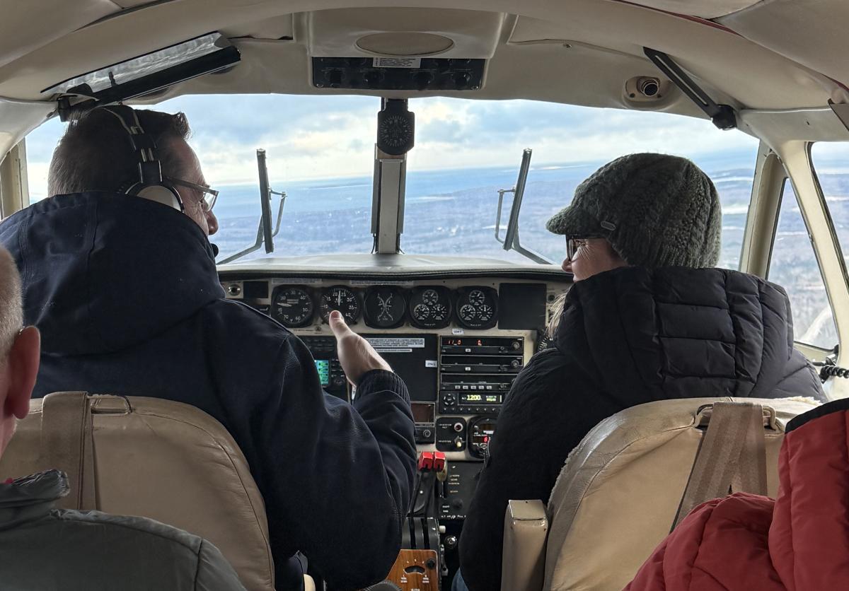 Pilot chats with passenger in the cockpit of a plane flying to Mackinac Island