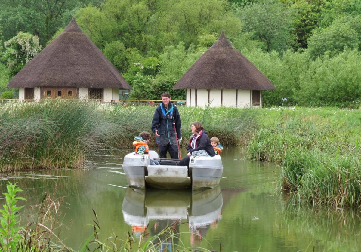 People in a boat on the water at Arundel Wetland Centre