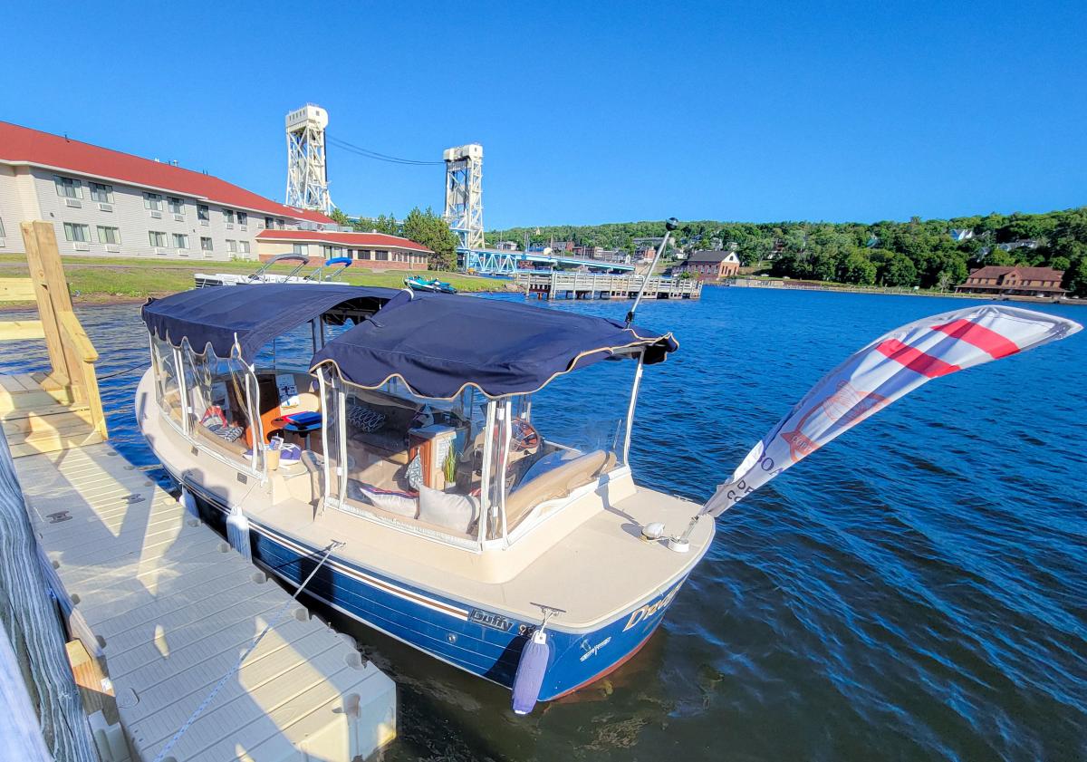small touring boat tied to a dock