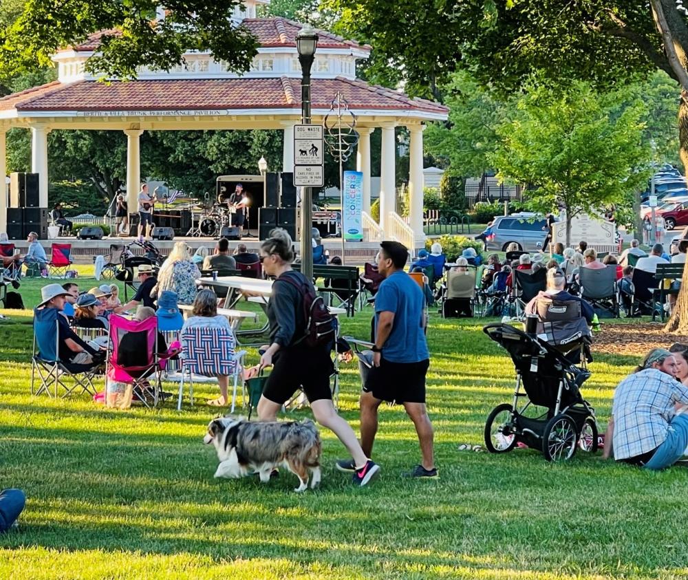 A couple bringing their dog to the Concerts in the Park during the summer.