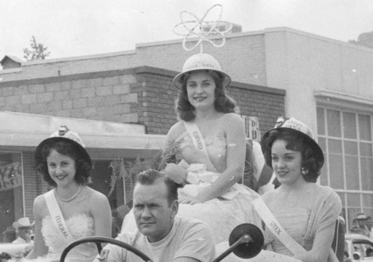 Four people sitting in a car; one three of them are women, one is wearing a uranium miner hat.
