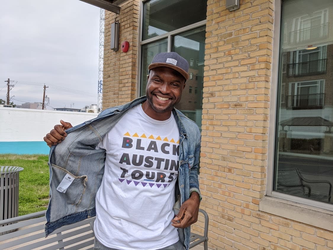Black Austin Tours Guide and Founder Javier Wallace wearing logo shirt in Austin Texas