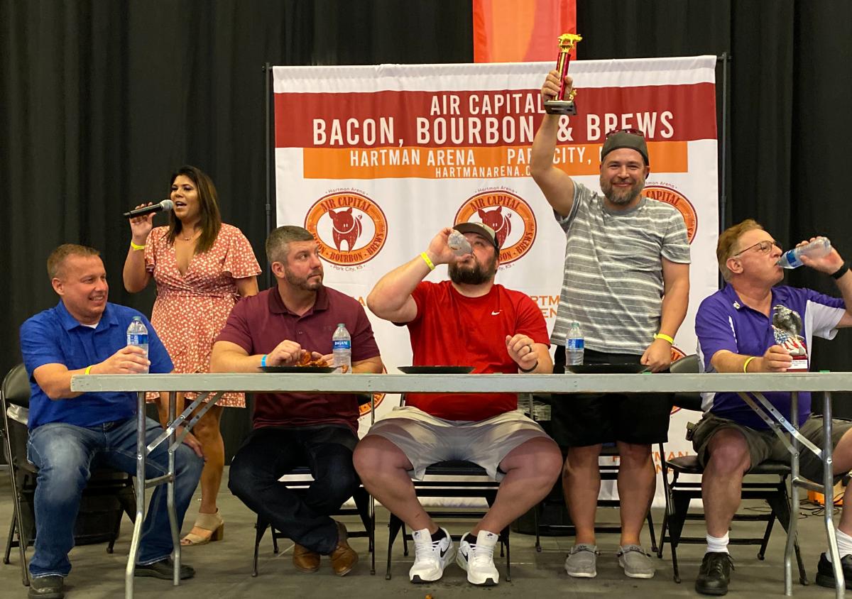 Four men compete in a bacon-eating contest at the annual Air Capital Bacon Bourbon & Brews Festival